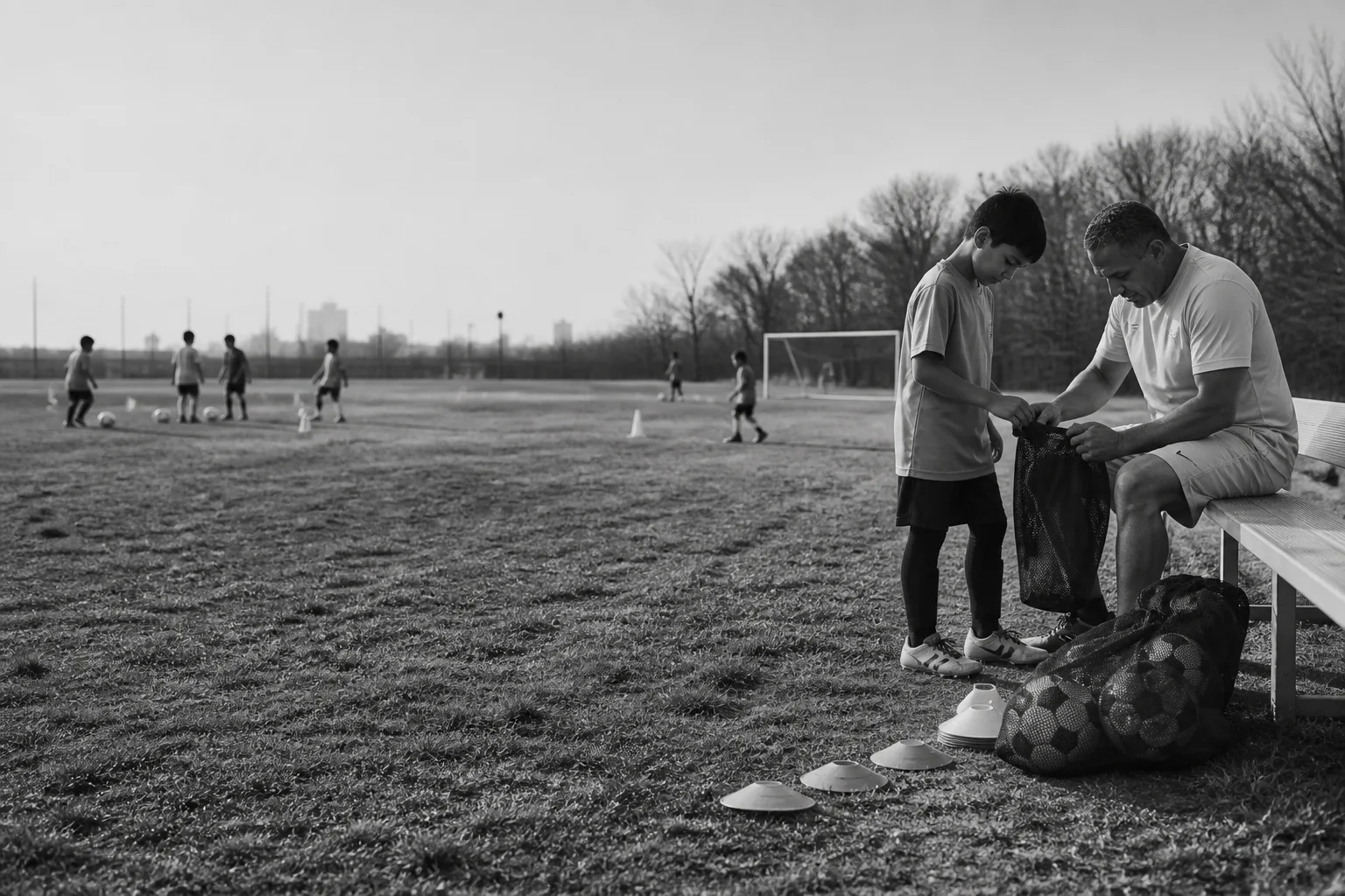 A mentor and young player preparing training equipment together