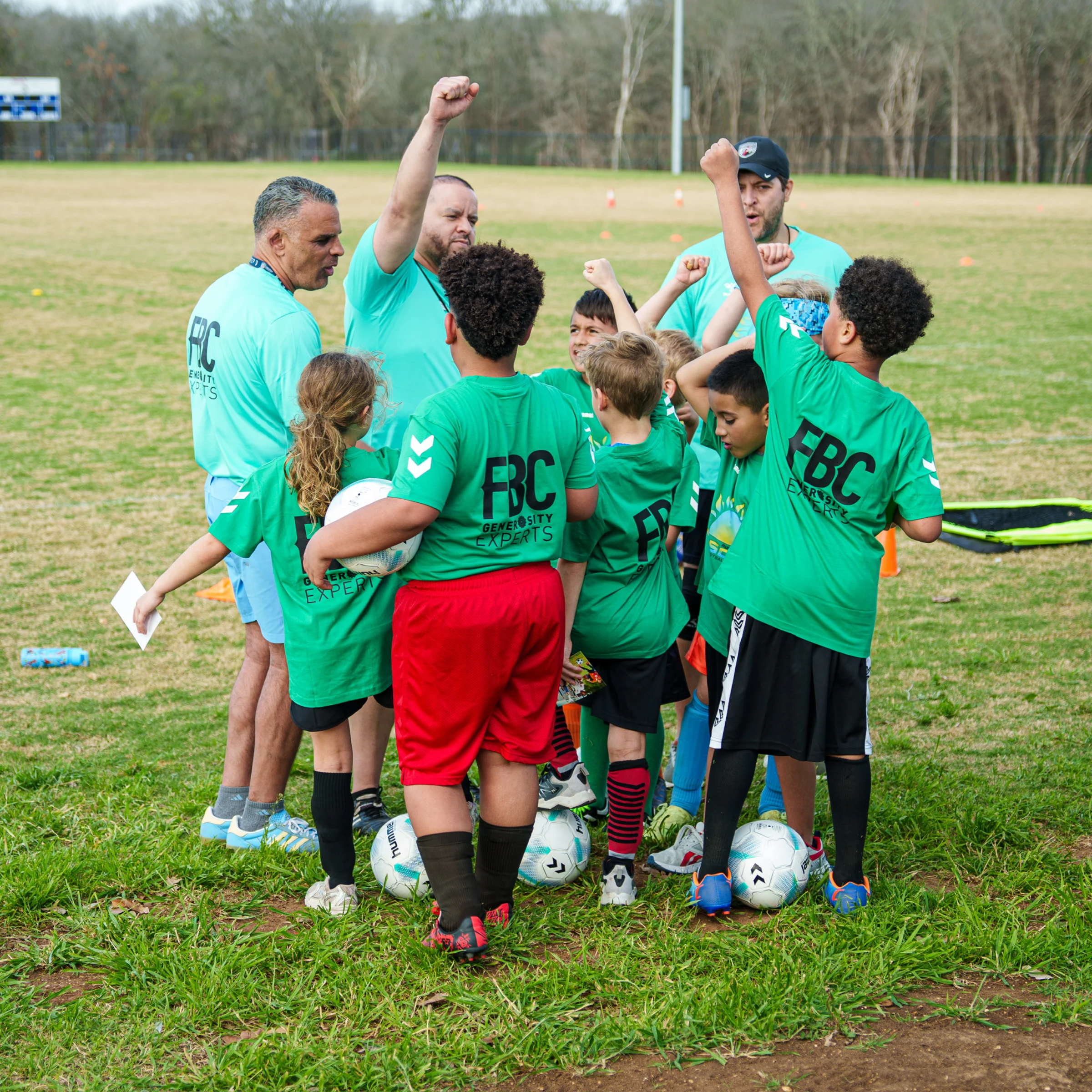 Coaches and young soccer players gathering together on the field